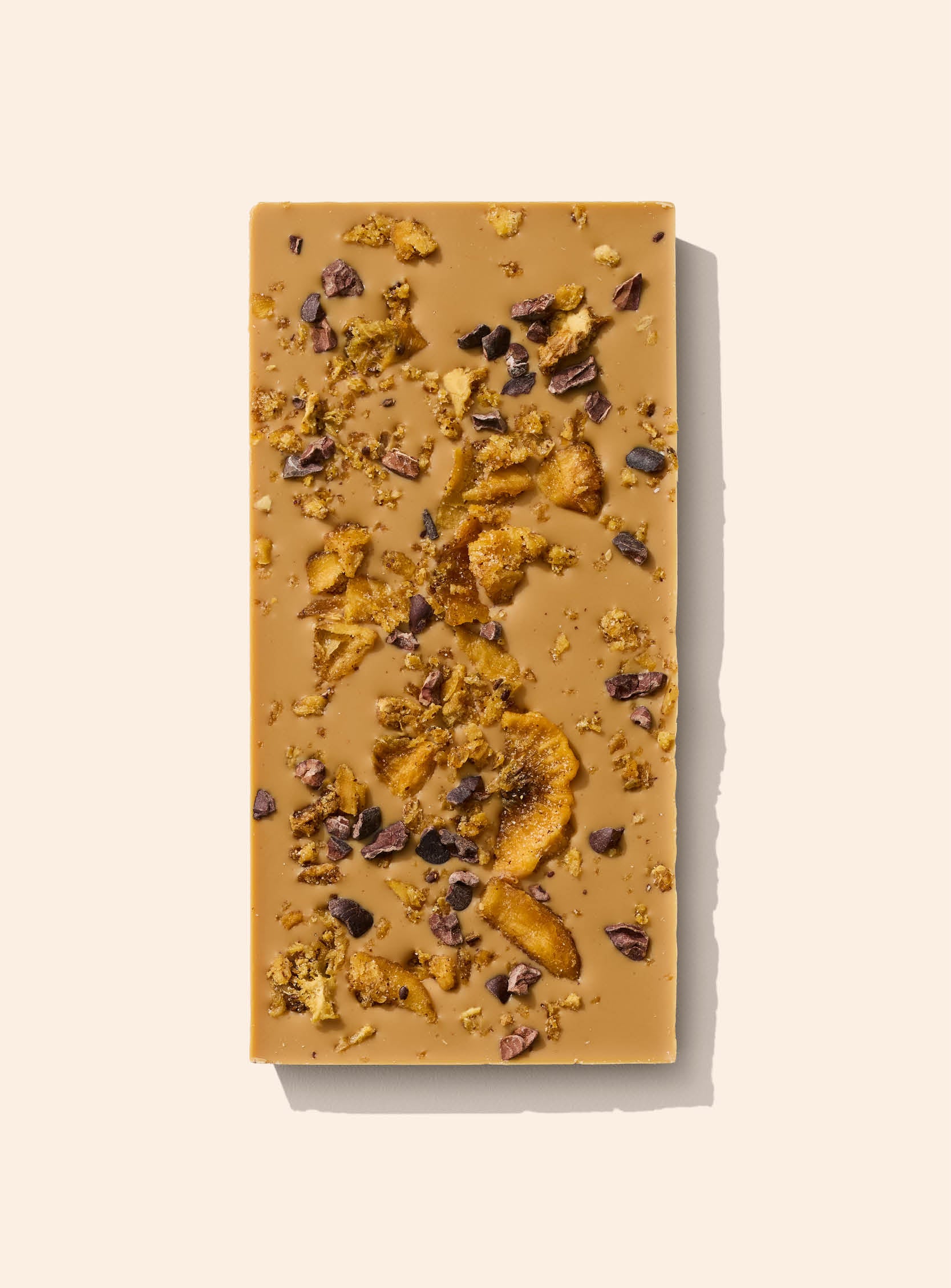 Premium caramelised white chocolate with smooth vanilla flavour, topped with golden kiwifruit pieces and cacao nibs.